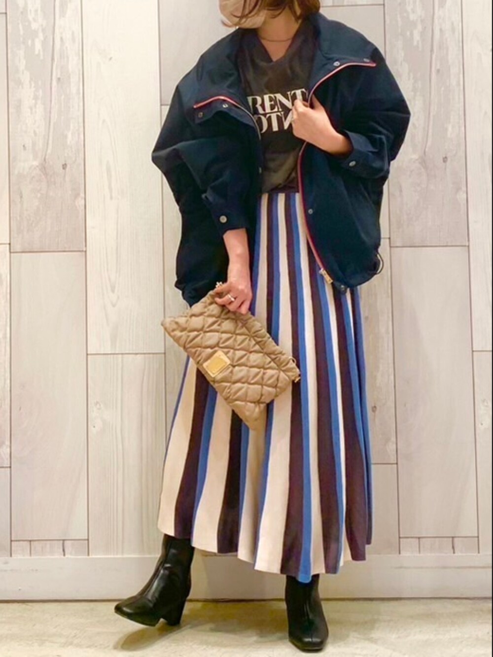 ブルー系のブルゾン、グレー系のTシャツ/カットソー、ベージュ系のスカートを着用したレディースの秋コーディネートの2枚目の写真