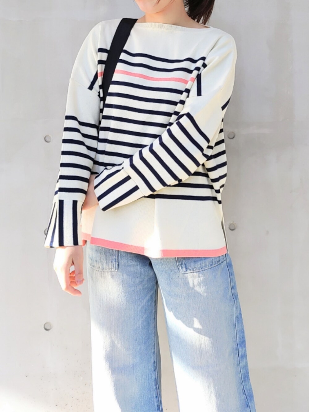 ブルー系のデニムパンツ、ホワイト系のスニーカー、ブラック系のバックパック/リュックを着用したレディースの冬コーディネートの5枚目の写真