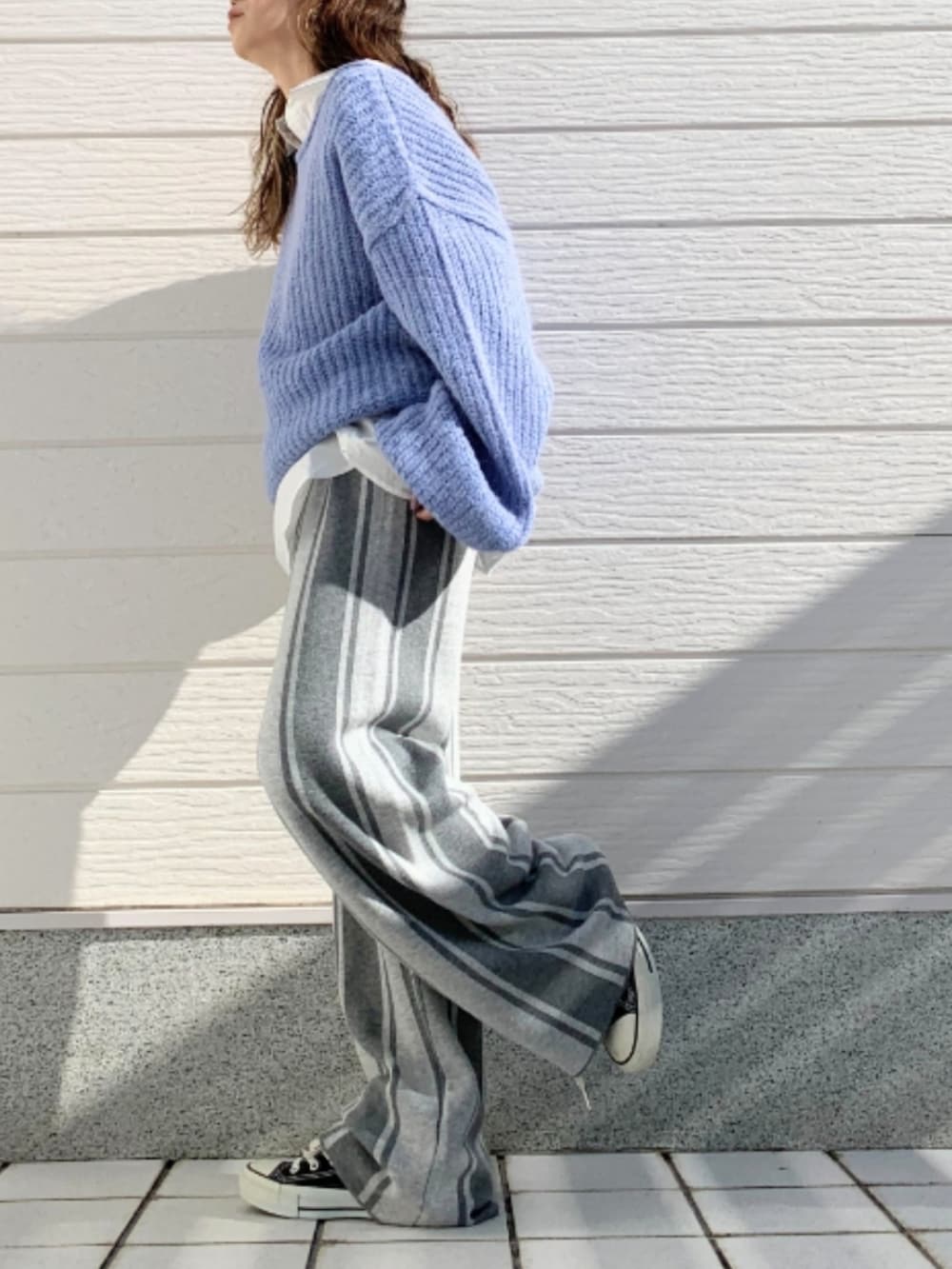 ブルー系のニット/セーター、ブラック系のスニーカー、グレー系のその他パンツを着用したレディースの冬コーディネートの2枚目の写真