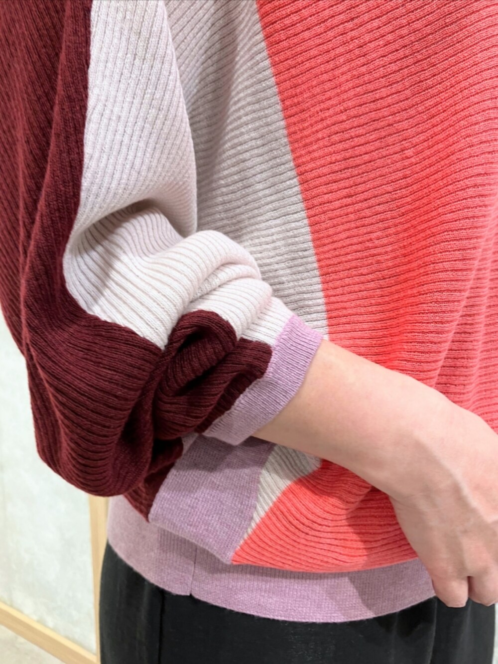 ブラック系のスニーカー、ブラック系のその他パンツ、レッド系のニット/セーターを着用したレディースの秋コーディネートの3枚目の写真