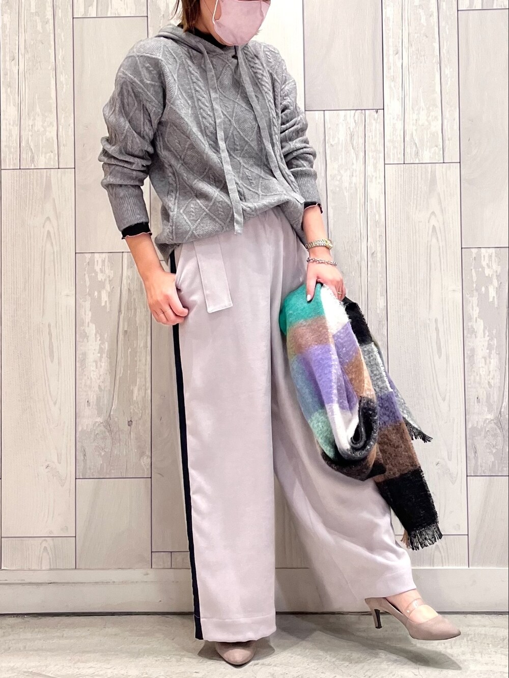 グレー系のニット/セーター、グレー系のその他パンツ、グリーン系のストール/ショールを着用したレディースの冬コーディネートの2枚目の写真