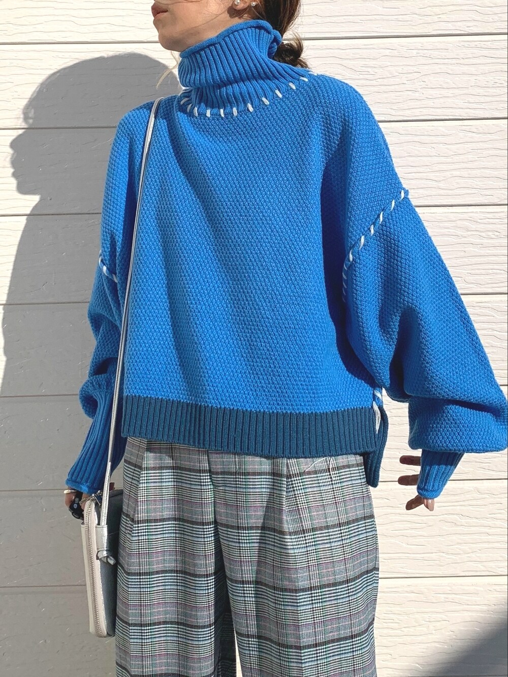 ブルー系のニット/セーター、シルバー系のショルダーバッグ、ブラウン系のその他パンツを着用したレディースの秋コーディネートの3枚目の写真