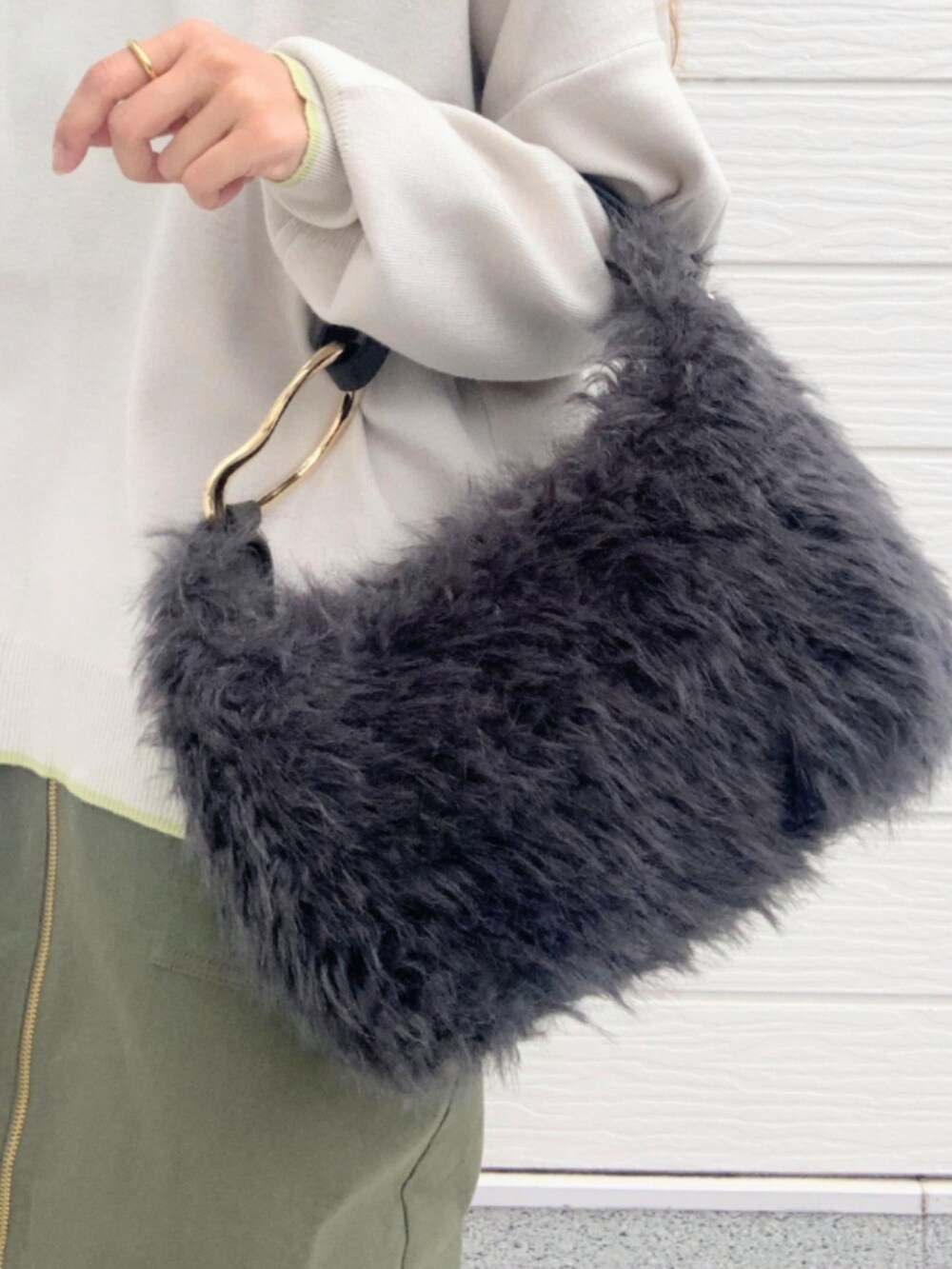 グリーン系のスカート、グレー系のハンドバッグ、グレー系のニット/セーターを着用したレディースの秋コーディネートの5枚目の写真