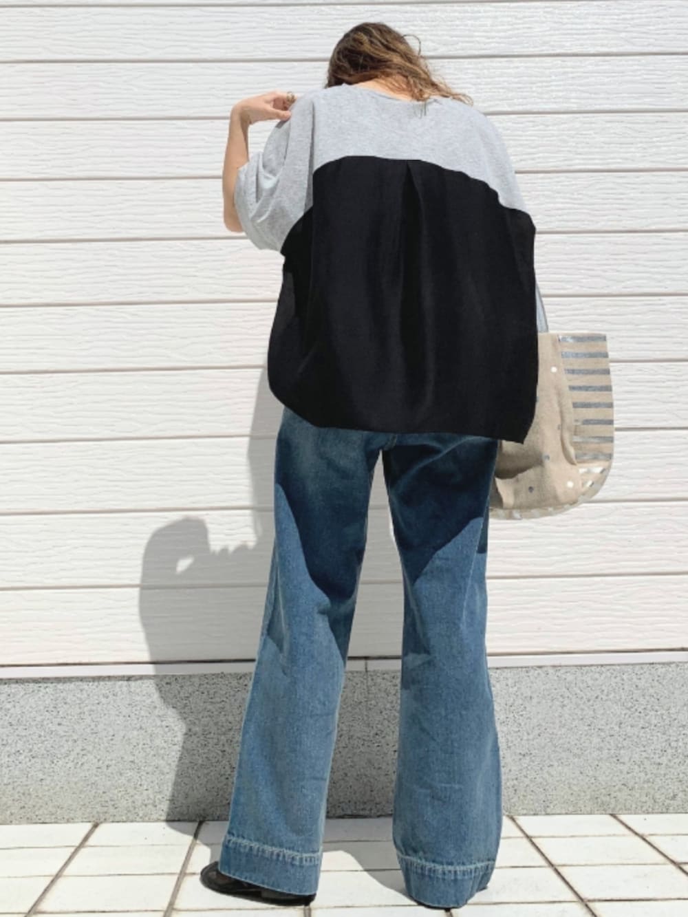 グレー系のTシャツ/カットソー、シルバー系のトートバッグ、ブラック系のパンプスを着用したレディースの春コーディネートの3枚目の写真