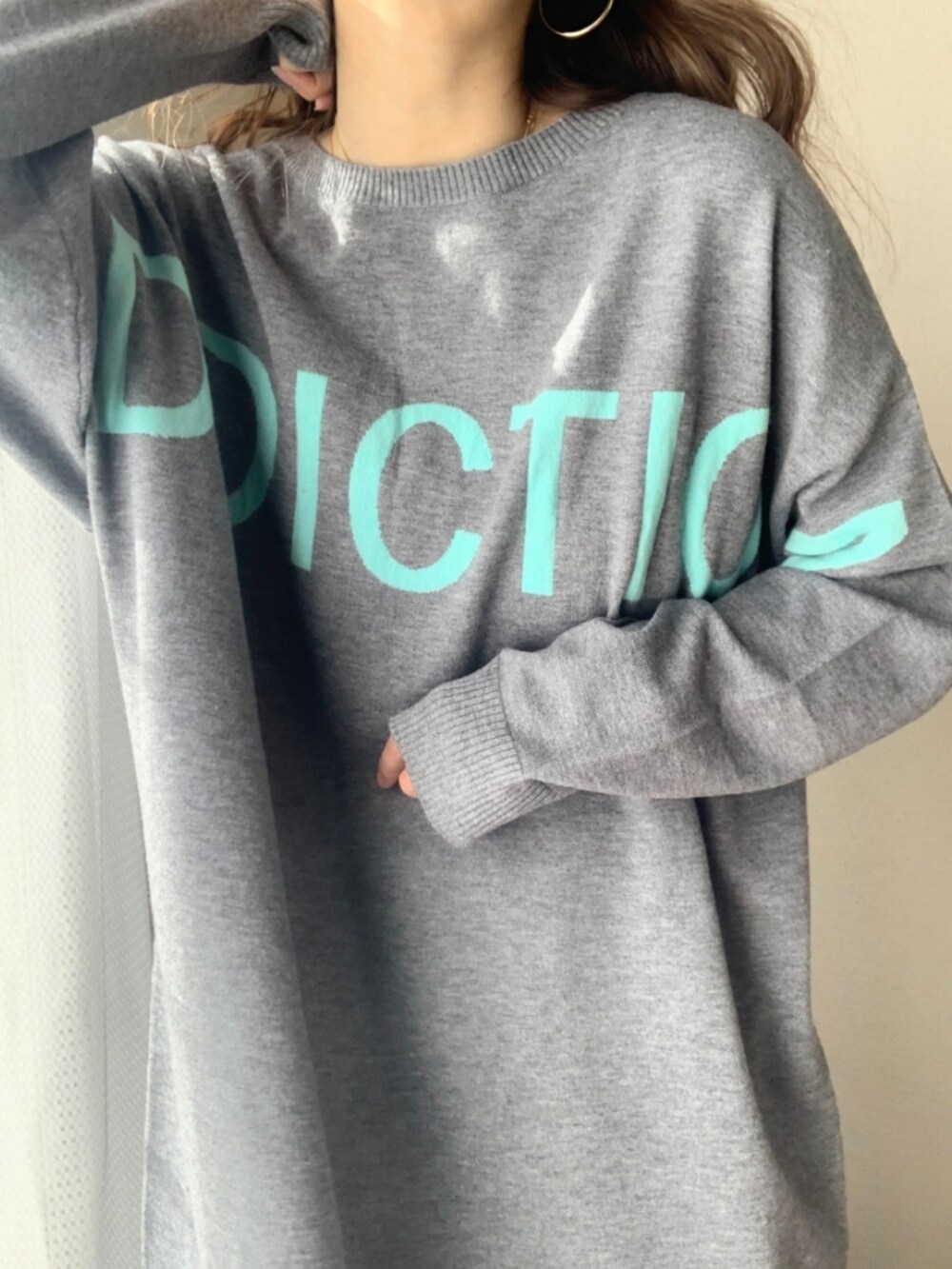 シルバー系のスカート、グレー系のニット/セーターを着用したレディースの冬コーディネートの5枚目の写真