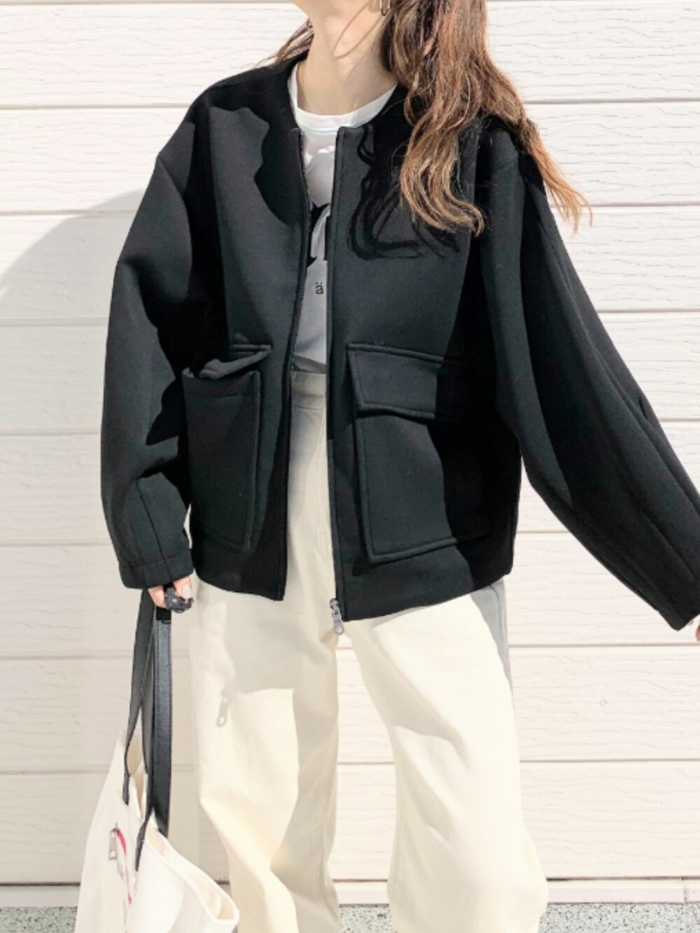 ホワイト系のトートバッグ、ホワイト系のTシャツ/カットソー、ホワイト系のデニムパンツを着用したレディースの冬コーディネートの4枚目の写真