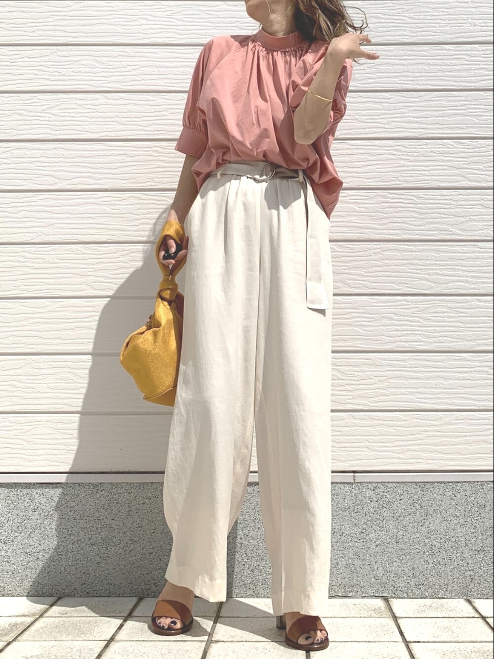 ピンク系のシャツ/ブラウス、イエロー系のショルダーバッグ、ブラウン系のサンダルを着用したレディースの春コーディネートの2枚目の写真