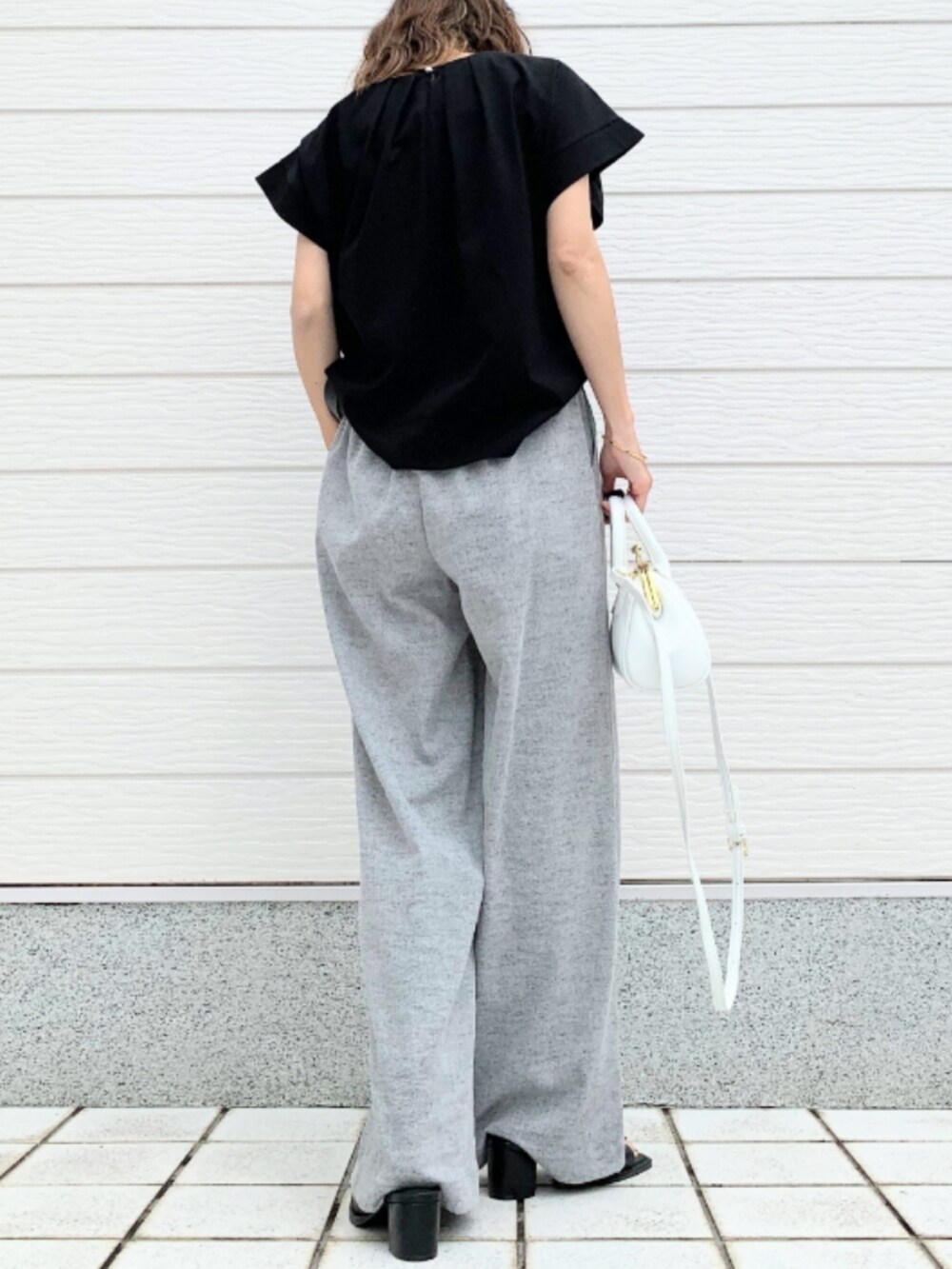 ブラック系のTシャツ/カットソー、ホワイト系のショルダーバッグ、グレー系のその他パンツを着用したレディースの春コーディネートの3枚目の写真