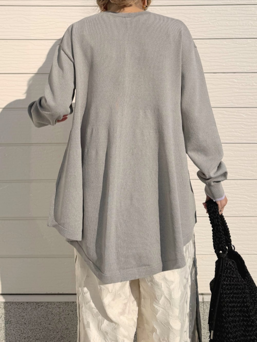 ホワイト系のその他パンツ、ブラック系のトートバッグ、グレー系のカーディガン/ボレロを着用したレディースの冬コーディネートの5枚目の写真