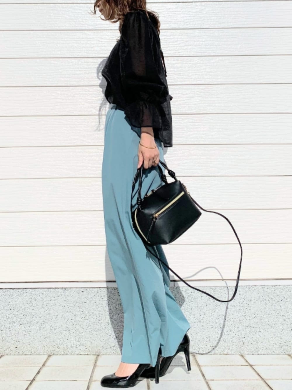 ブラック系のハンドバッグ、ブルー系のその他パンツ、ブラック系のシャツ/ブラウスを着用したレディースの春コーディネートの2枚目の写真