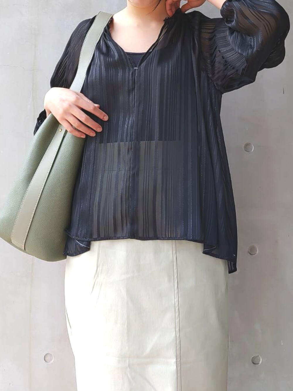 ブラック系のシャツ/ブラウス、グリーン系のスカート、ブラック系のサンダルを着用したレディースの春コーディネートの3枚目の写真