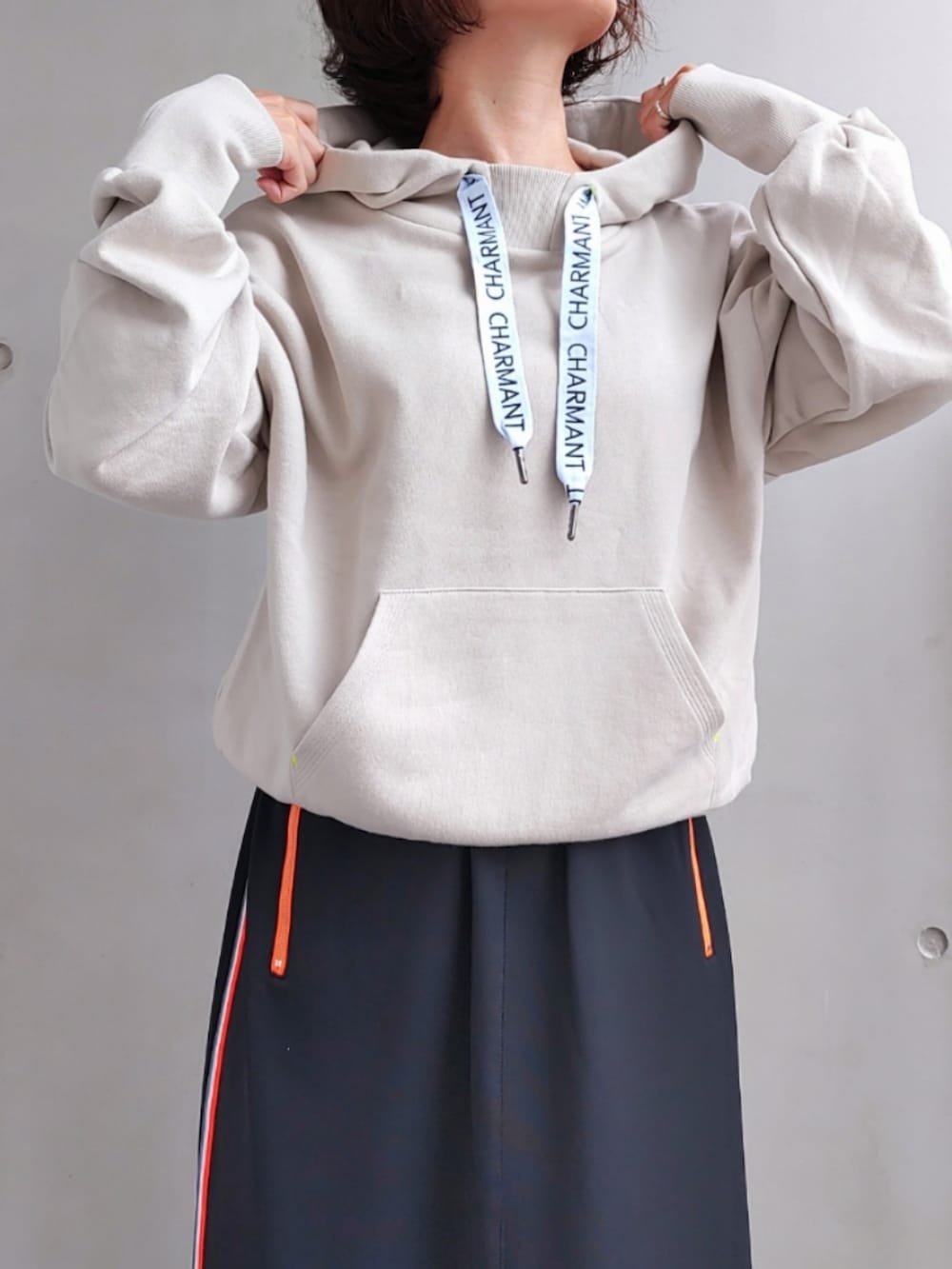 ブラック系のスカート、ベージュ系のパーカー、ホワイト系のスニーカーを着用したレディースの秋コーディネートの3枚目の写真