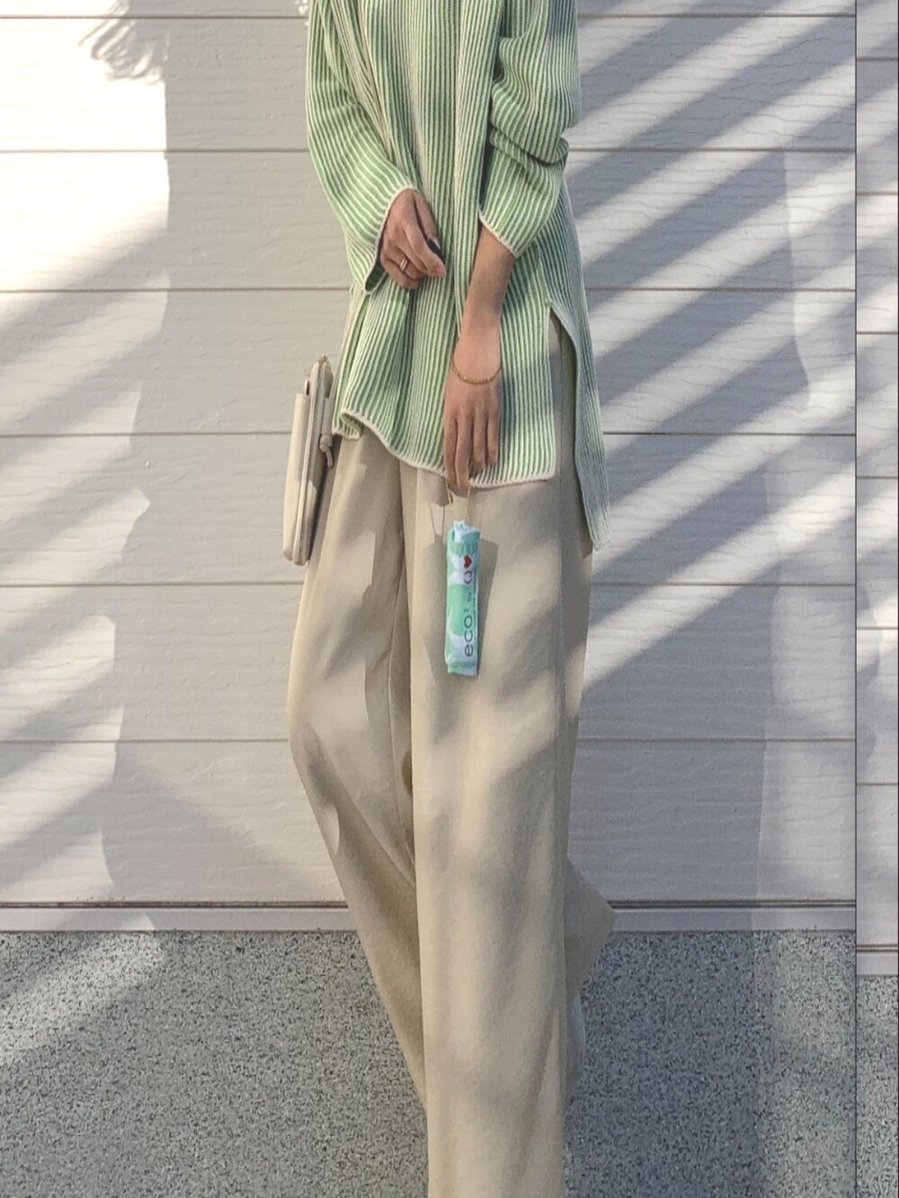 ベージュ系のその他パンツ、グリーン系のニット/セーター、ホワイト系のショルダーバッグを着用したレディースの冬コーディネートの5枚目の写真