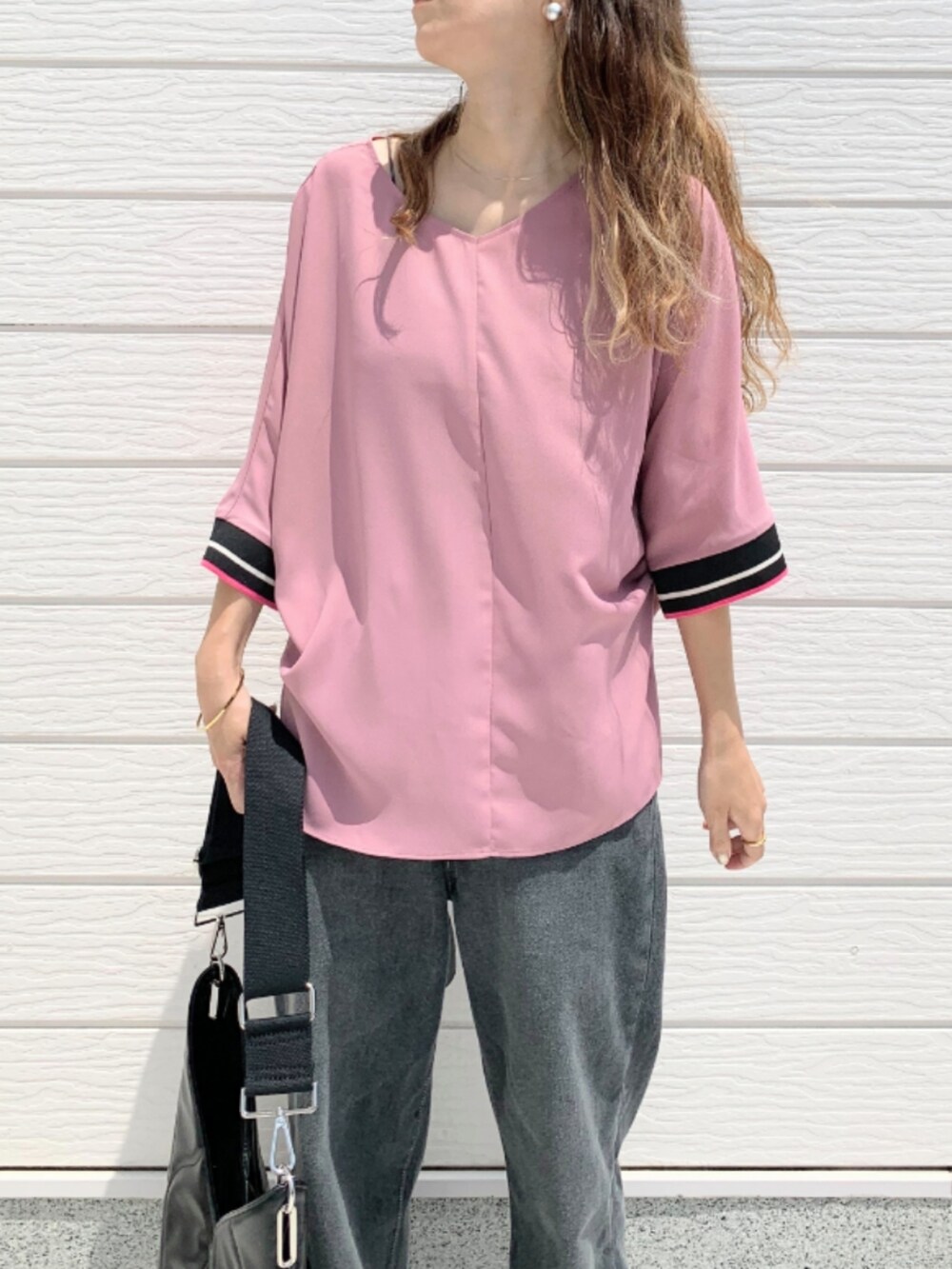 グレー系のデニムパンツ、ブラック系のハンドバッグ、ピンク系のシャツ/ブラウスを着用したレディースの夏コーディネートの3枚目の写真