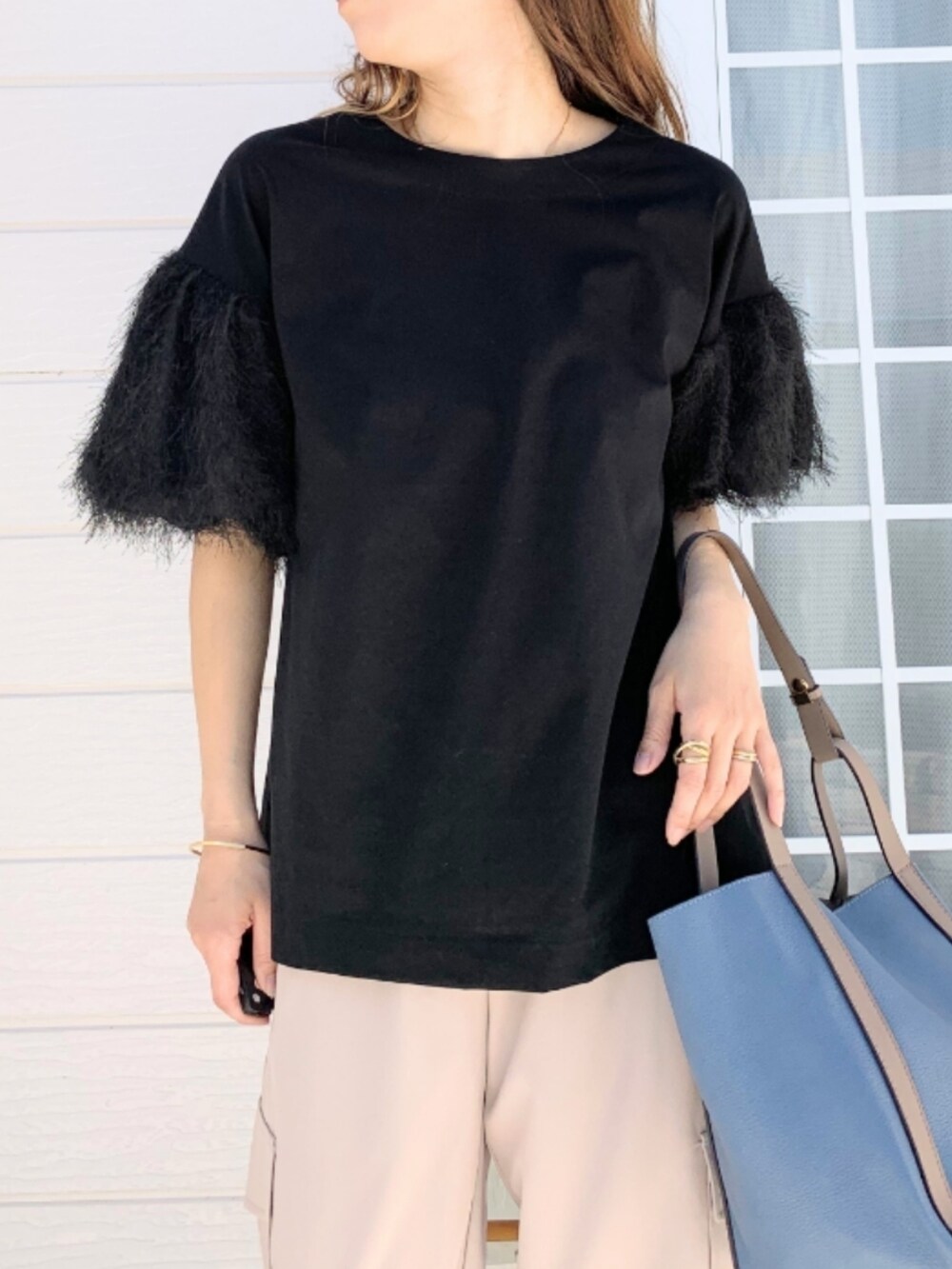 ベージュ系のカーゴパンツ、ブラック系のTシャツ/カットソー、ブルー系のトートバッグを着用したレディースの春コーディネートの4枚目の写真