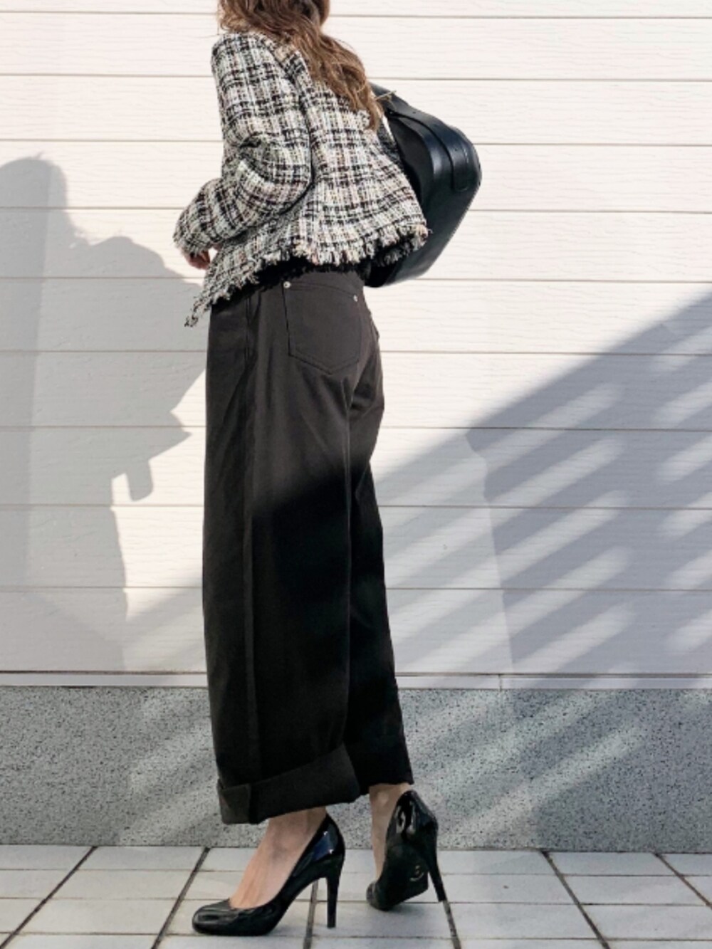 ブラック系のデニムパンツ、ホワイト系のノーカラージャケットを着用したレディースの冬コーディネートの2枚目の写真