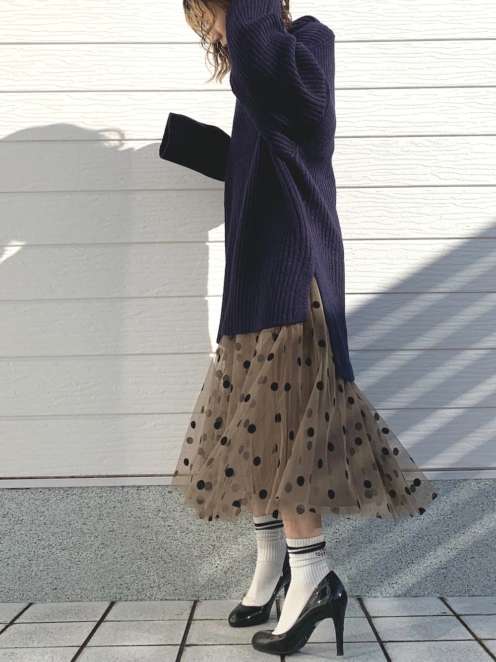 ブラウン系のスカート、ブルー系のニット/セーターを着用したレディースの冬コーディネートの2枚目の写真