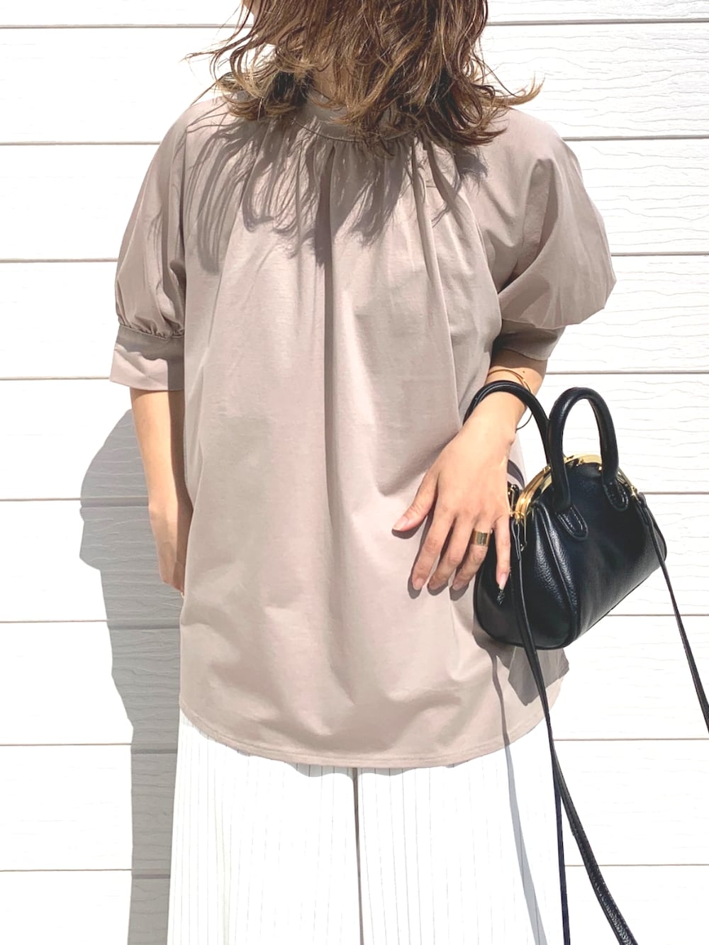 ブラック系のショルダーバッグ、ホワイト系のその他パンツ、ブラック系のサンダルを着用したレディースの春コーディネートの4枚目の写真