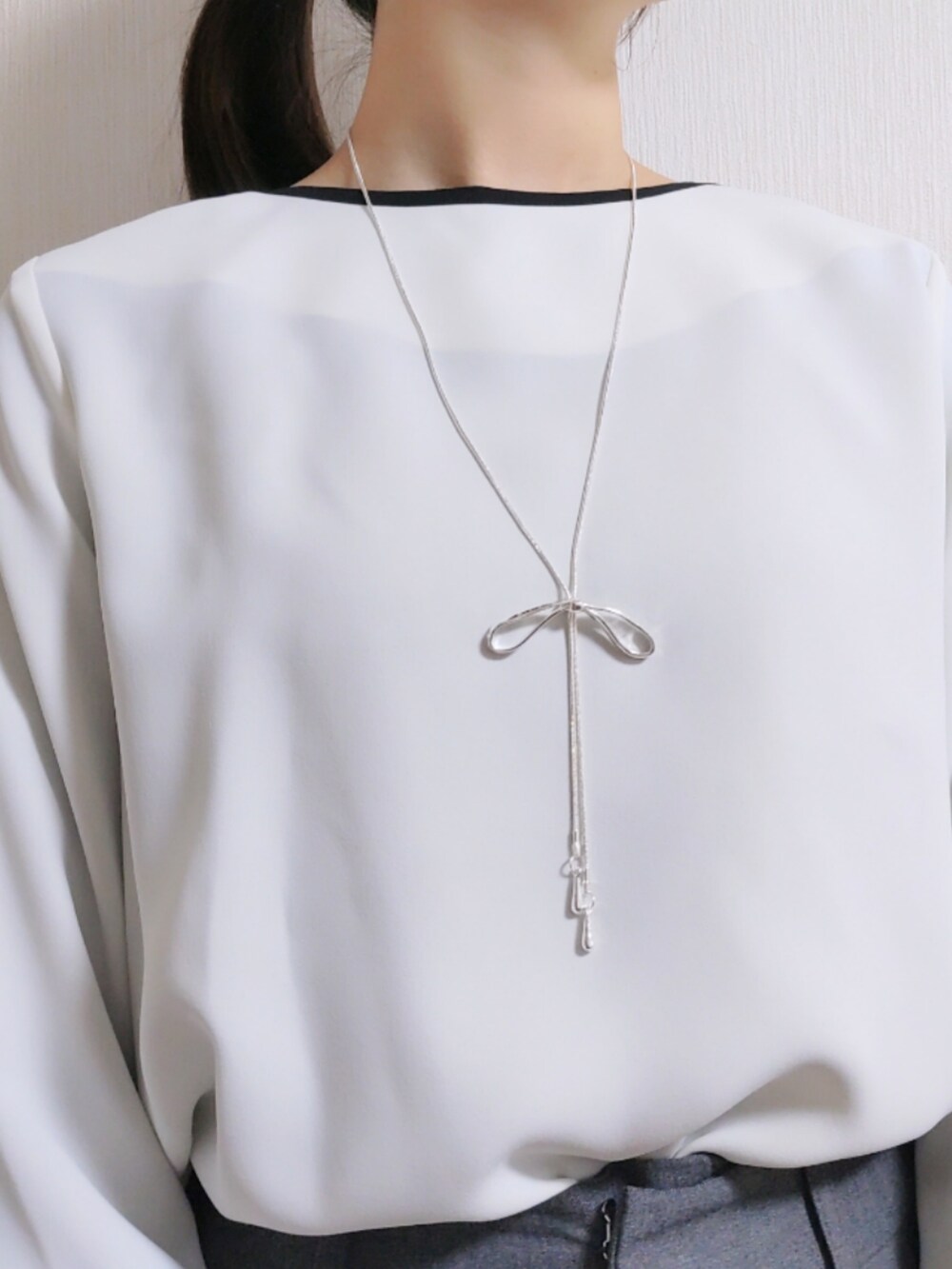 グレー系のスラックス、グレー系のノーカラージャケット、ホワイト系のシャツ/ブラウスを着用したレディースの冬コーディネートの5枚目の写真