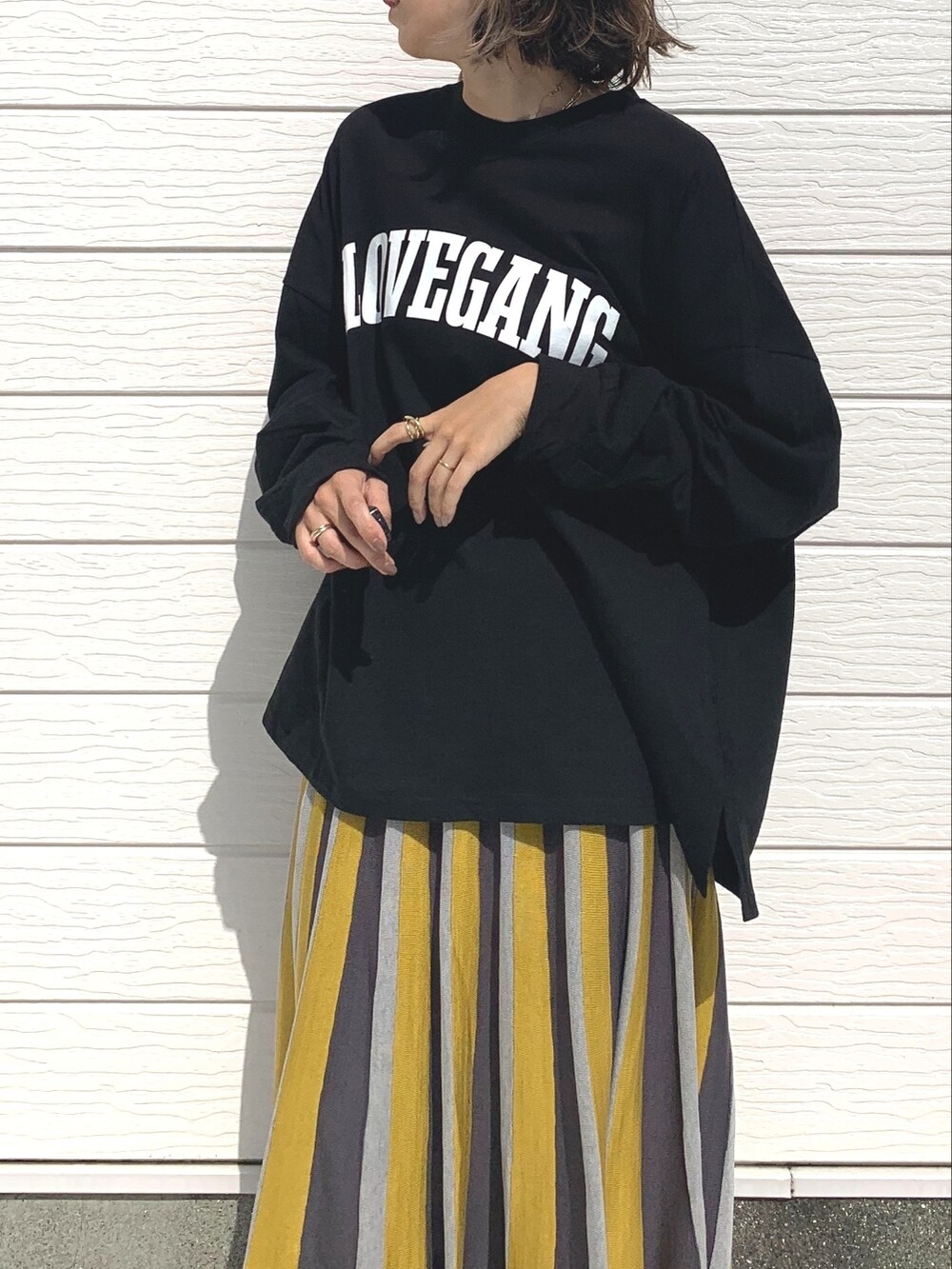 ブラック系のTシャツ/カットソー、ブラック系のローファー、イエロー系のスカートを着用したレディースの秋コーディネートの3枚目の写真