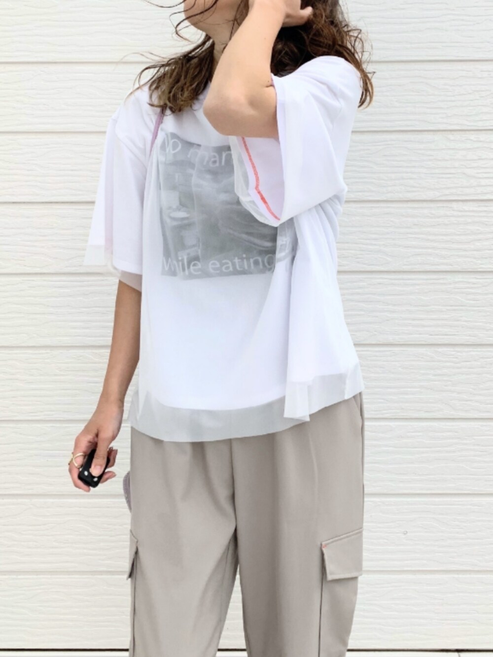 ベージュ系のカーゴパンツ、ホワイト系のTシャツ/カットソー、パープル系のショルダーバッグを着用したレディースの春コーディネートの3枚目の写真