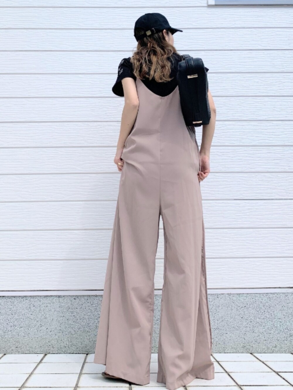 ブラウン系のサンダル、ブラック系のTシャツ/カットソー、ベージュ系のサロペット/オーバーオールを着用したレディースの春コーディネートの3枚目の写真