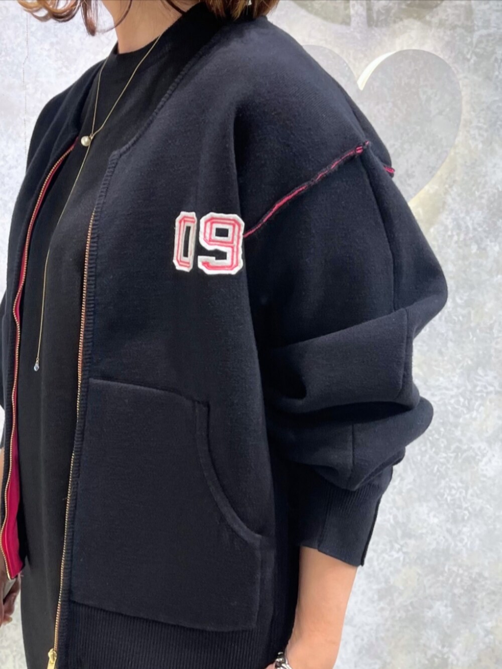 グレー系のブーツ、ブラック系のブルゾン、ブラック系のワンピースを着用したレディースの秋コーディネートの4枚目の写真