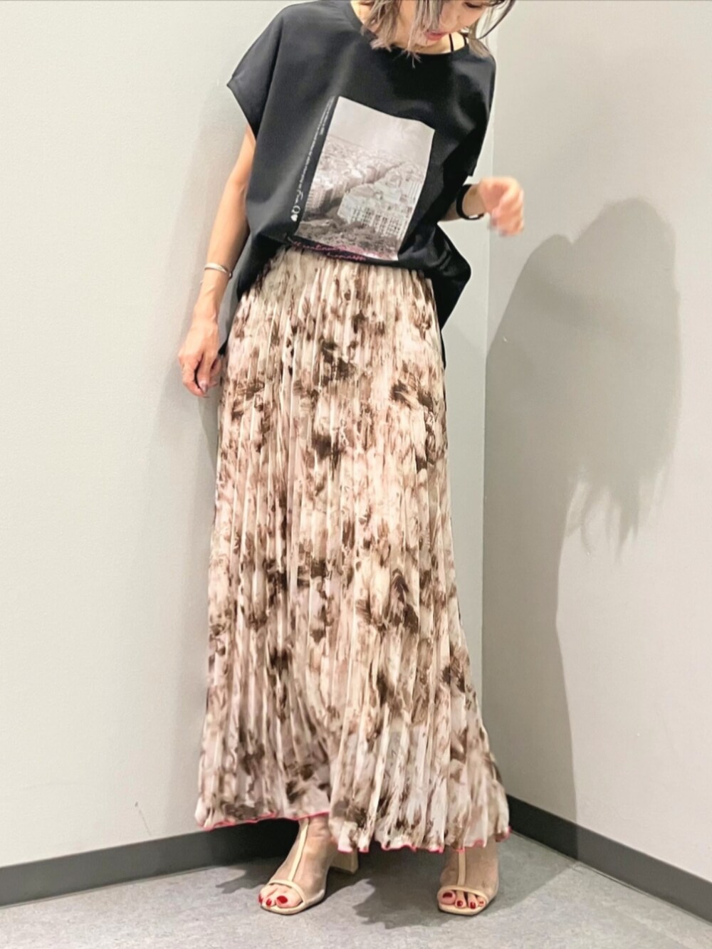 ベージュ系のスカート、ベージュ系のブルゾン、グレー系のTシャツ/カットソーを着用したレディースの秋コーディネートの2枚目の写真