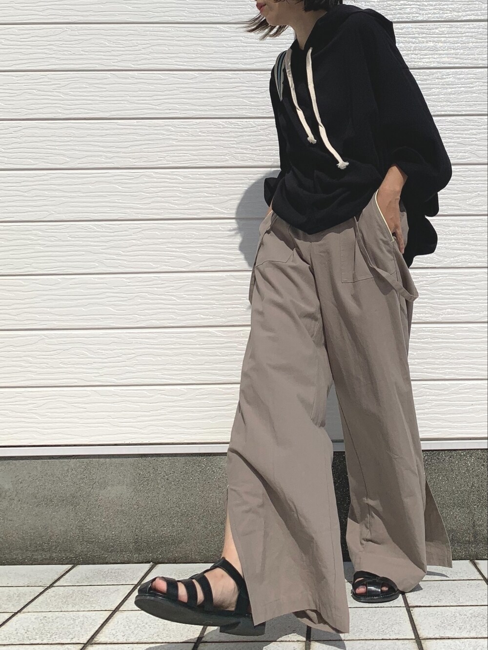 ベージュ系のその他パンツ、ブラック系のパーカー、ベージュ系のショルダーバッグを着用したレディースの夏コーディネートの2枚目の写真