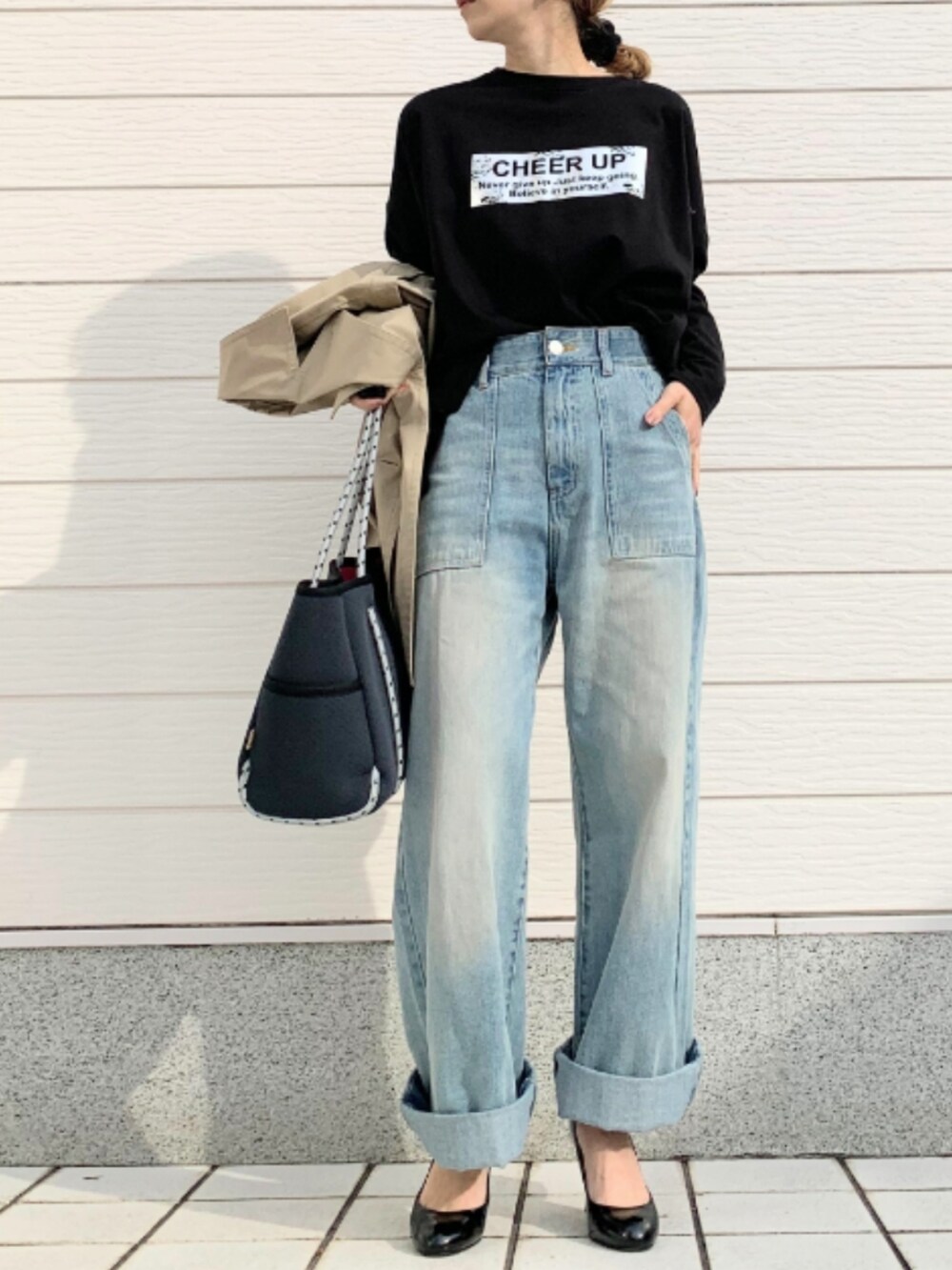 ブルー系のデニムパンツ、ブルー系のトートバッグ、ブラック系のTシャツ/カットソーを着用したレディースの冬コーディネートの3枚目の写真