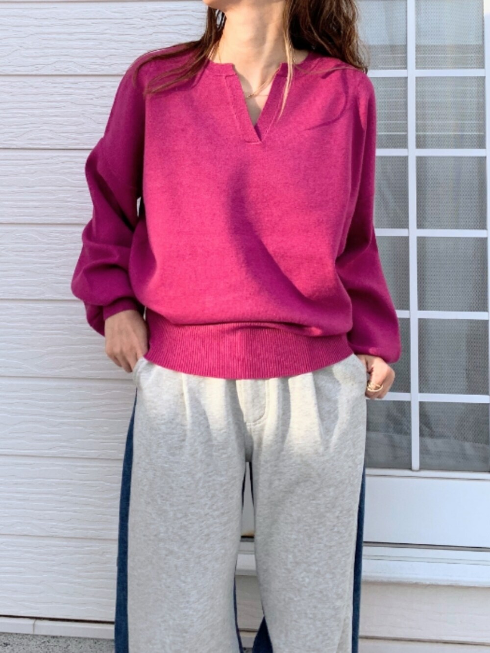 グレー系のデニムパンツ、シルバー系のスニーカー、ピンク系のニット/セーターを着用したレディースの冬コーディネートの2枚目の写真