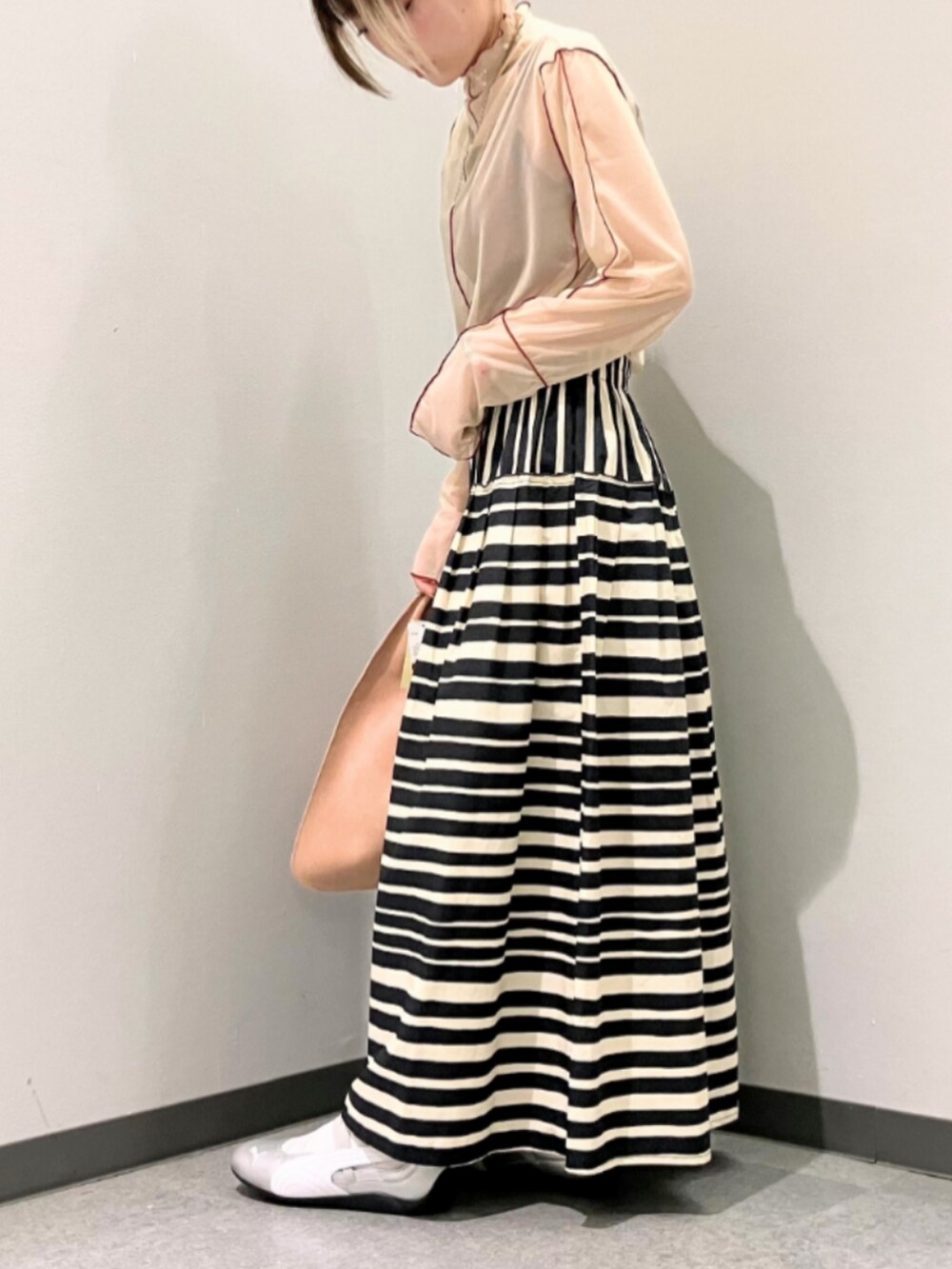 ベージュ系のトートバッグ、ブラック系のスカート、ベージュ系のTシャツ/カットソーを着用したレディースの夏コーディネートの2枚目の写真