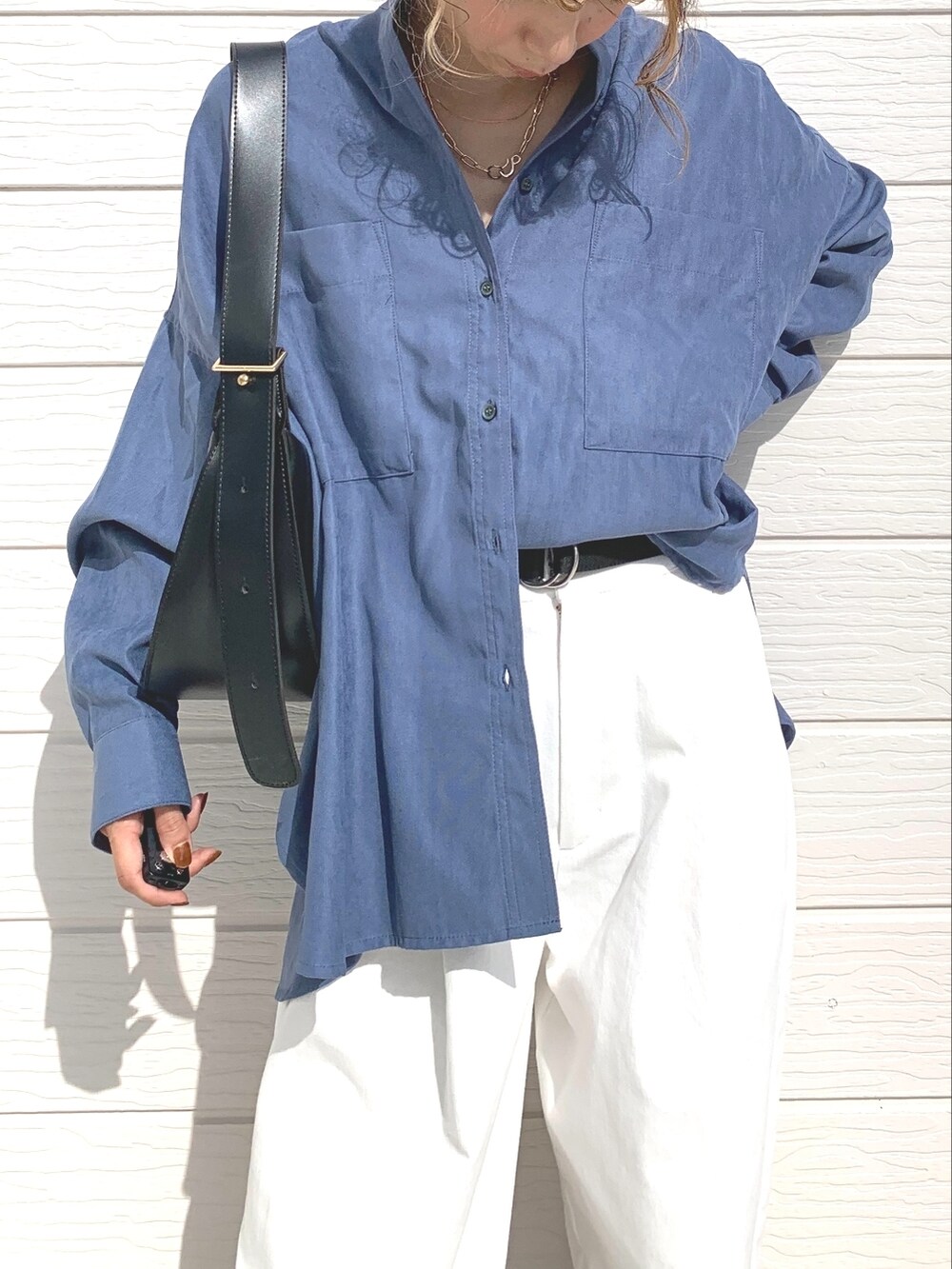 ホワイト系のデニムパンツ、ブラック系のショルダーバッグ、ブラック系のスニーカーを着用したレディースの秋コーディネートの3枚目の写真