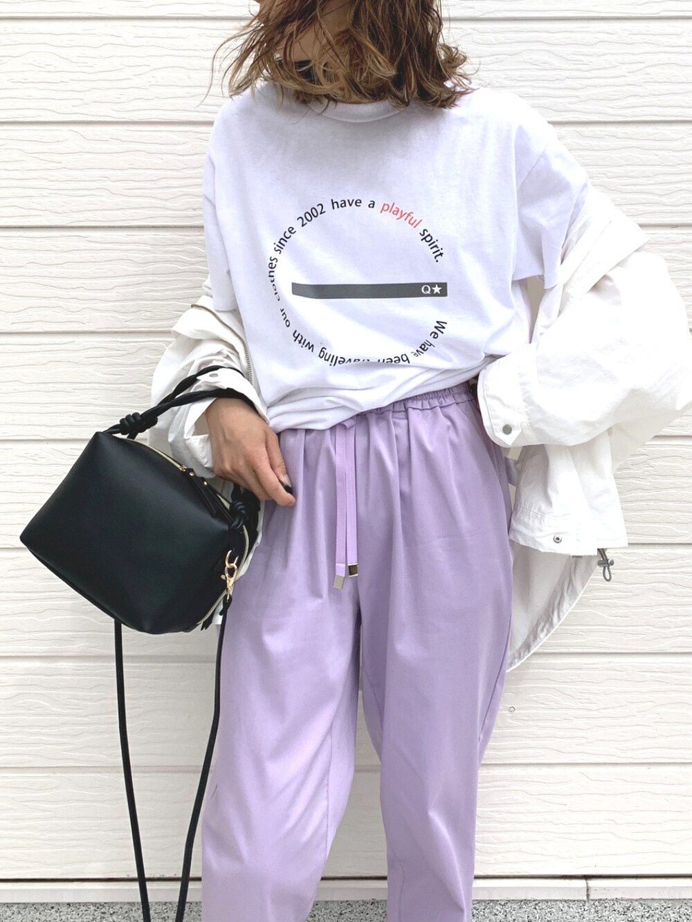 パープル系のその他パンツ、ホワイト系のマウンテンパーカー、ブラック系のハンドバッグを着用したレディースの春コーディネートの3枚目の写真