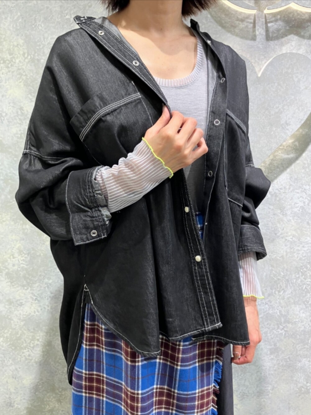 グレー系のブーツ、ブルー系のスカート、グレー系のTシャツ/カットソーを着用したレディースの秋コーディネートの4枚目の写真