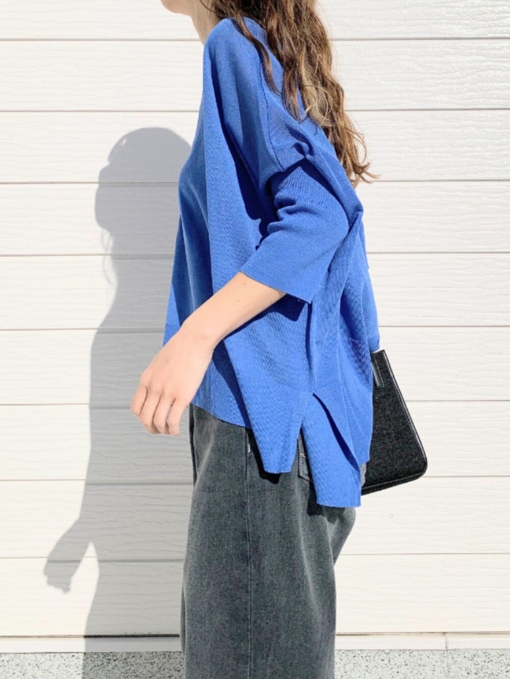 グレー系のデニムパンツ、ブラック系のショルダーバッグ、ブルー系のカーディガン/ボレロを着用したレディースの春コーディネートの5枚目の写真