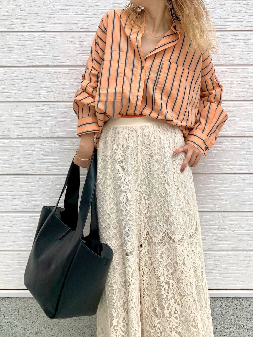 オレンジ系のシャツ/ブラウス、ホワイト系のその他パンツ、ブラック系のトートバッグを着用したレディースの夏コーディネートの3枚目の写真