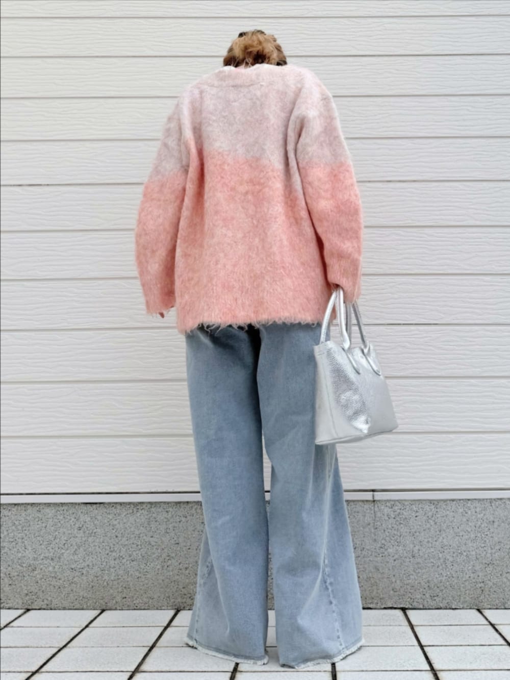 シルバー系のトートバッグ、ホワイト系のTシャツ/カットソー、ブルー系のデニムパンツを着用したレディースの冬コーディネートの3枚目の写真