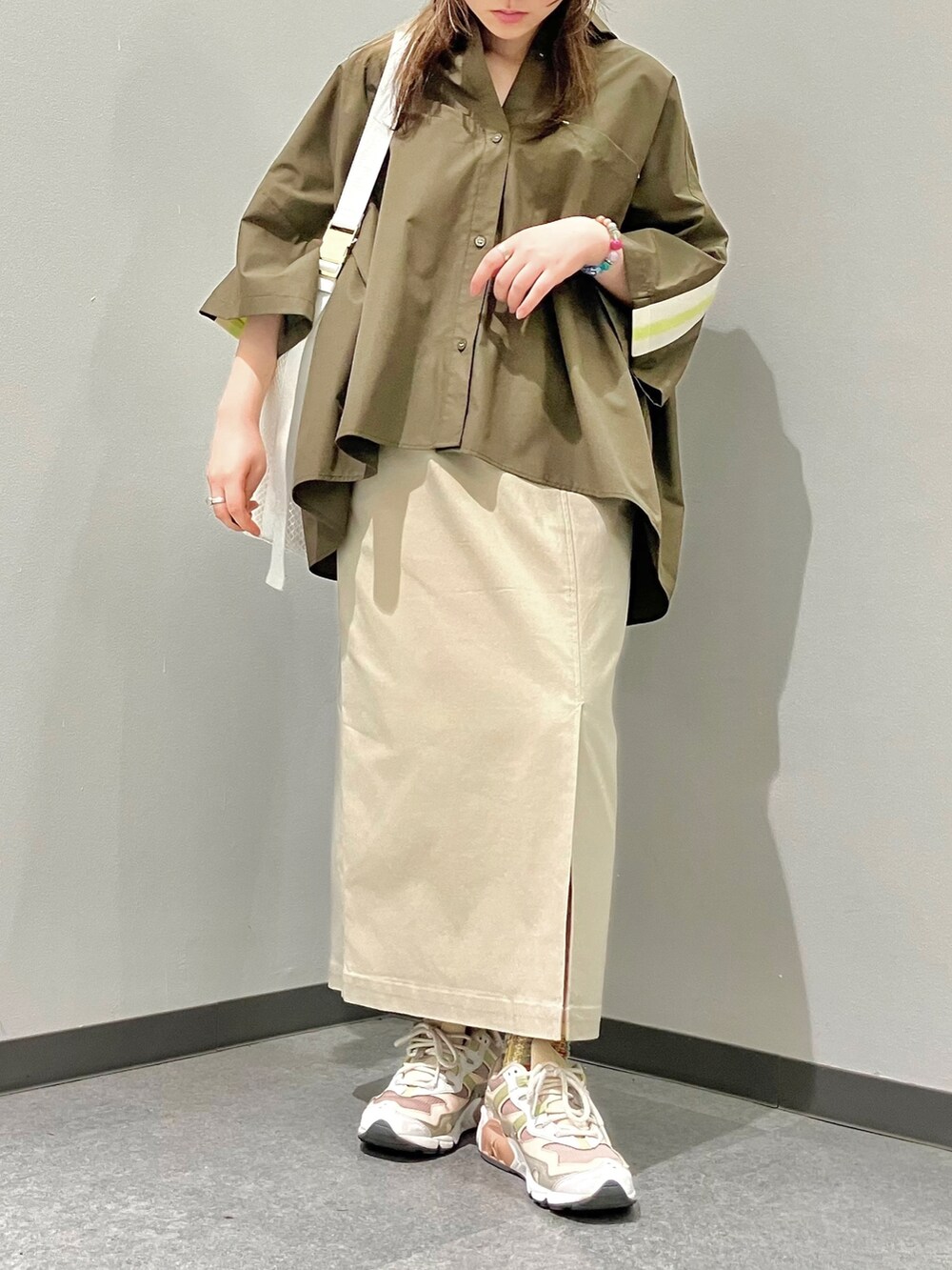 ホワイト系のショルダーバッグ、グリーン系のシャツ/ブラウス、ベージュ系のスカートを着用したレディースの春コーディネートの2枚目の写真