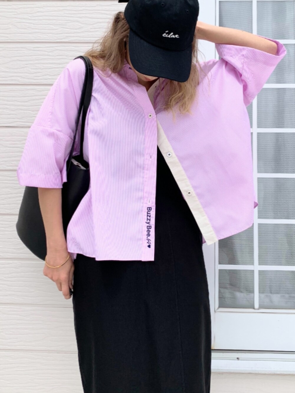 ブラック系のトートバッグ、ブラック系のキャミソール、ブラック系のスカートを着用したレディースの春コーディネートの4枚目の写真