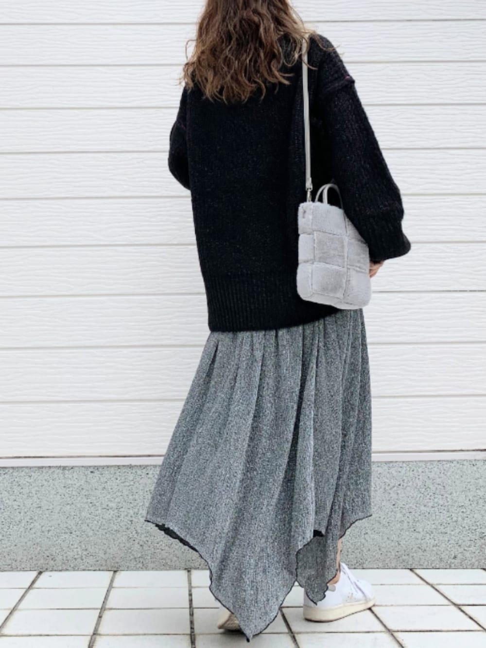 ホワイト系のスニーカー、グレー系のショルダーバッグ、ブラック系のニット/セーターを着用したレディースの秋コーディネートの2枚目の写真