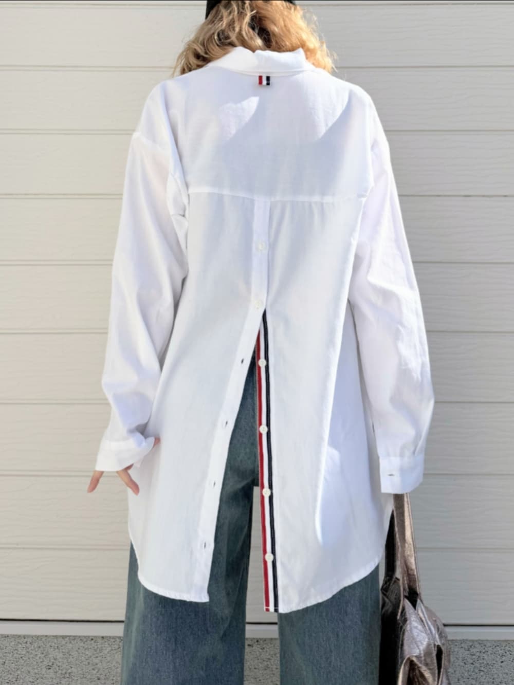 グレー系のトートバッグ、ホワイト系のシャツ/ブラウス、ブラック系のニット/セーターを着用したレディースの冬コーディネートの5枚目の写真