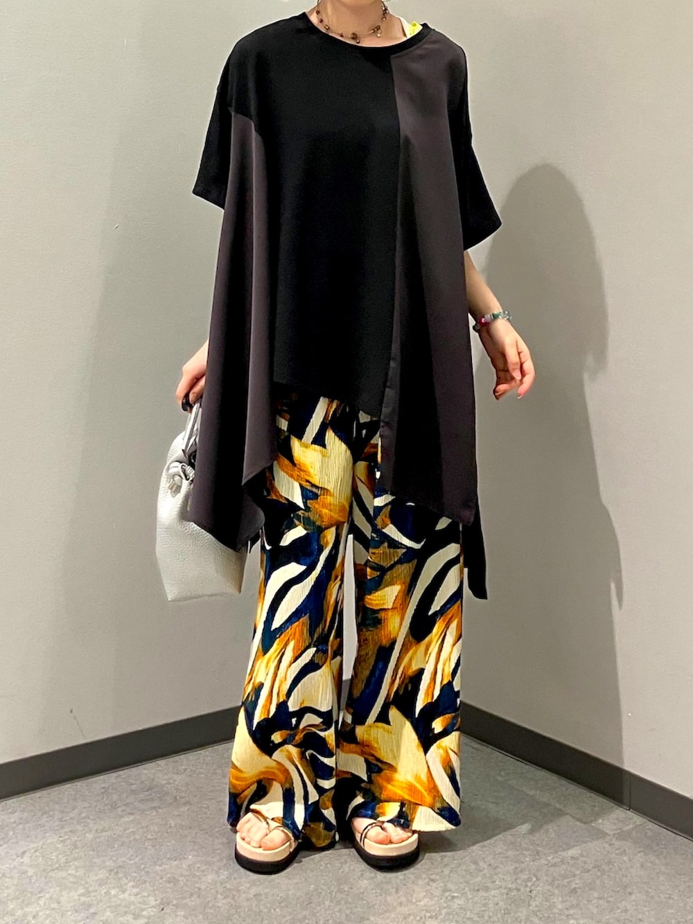 ブラック系のTシャツ/カットソー、ブルー系のその他パンツ、シルバー系のトートバッグを着用したレディースの夏コーディネートの3枚目の写真