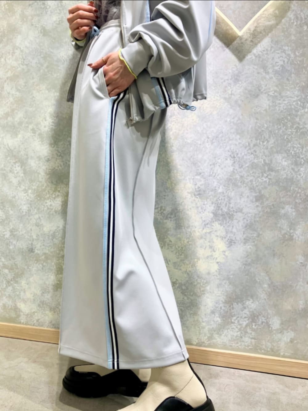 ホワイト系のブーツ、グレー系のその他アウター、グレー系のスカートを着用したレディースの春コーディネートの5枚目の写真