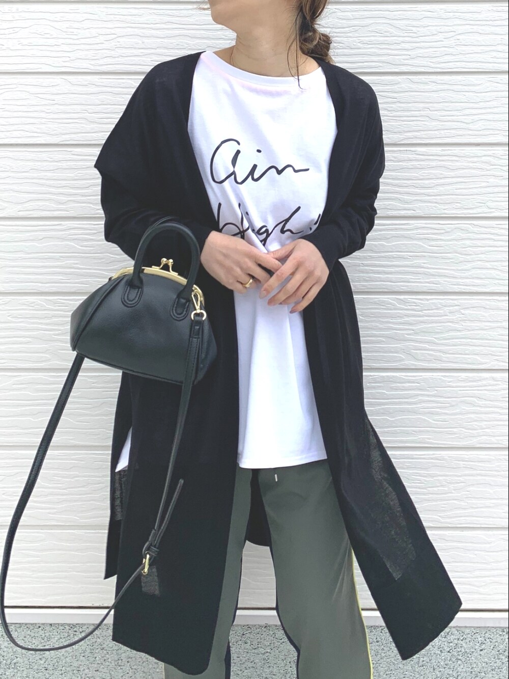 ホワイト系のTシャツ/カットソー、ブラック系のサンダル、ブラック系のカーディガン/ボレロを着用したレディースの春コーディネートの3枚目の写真