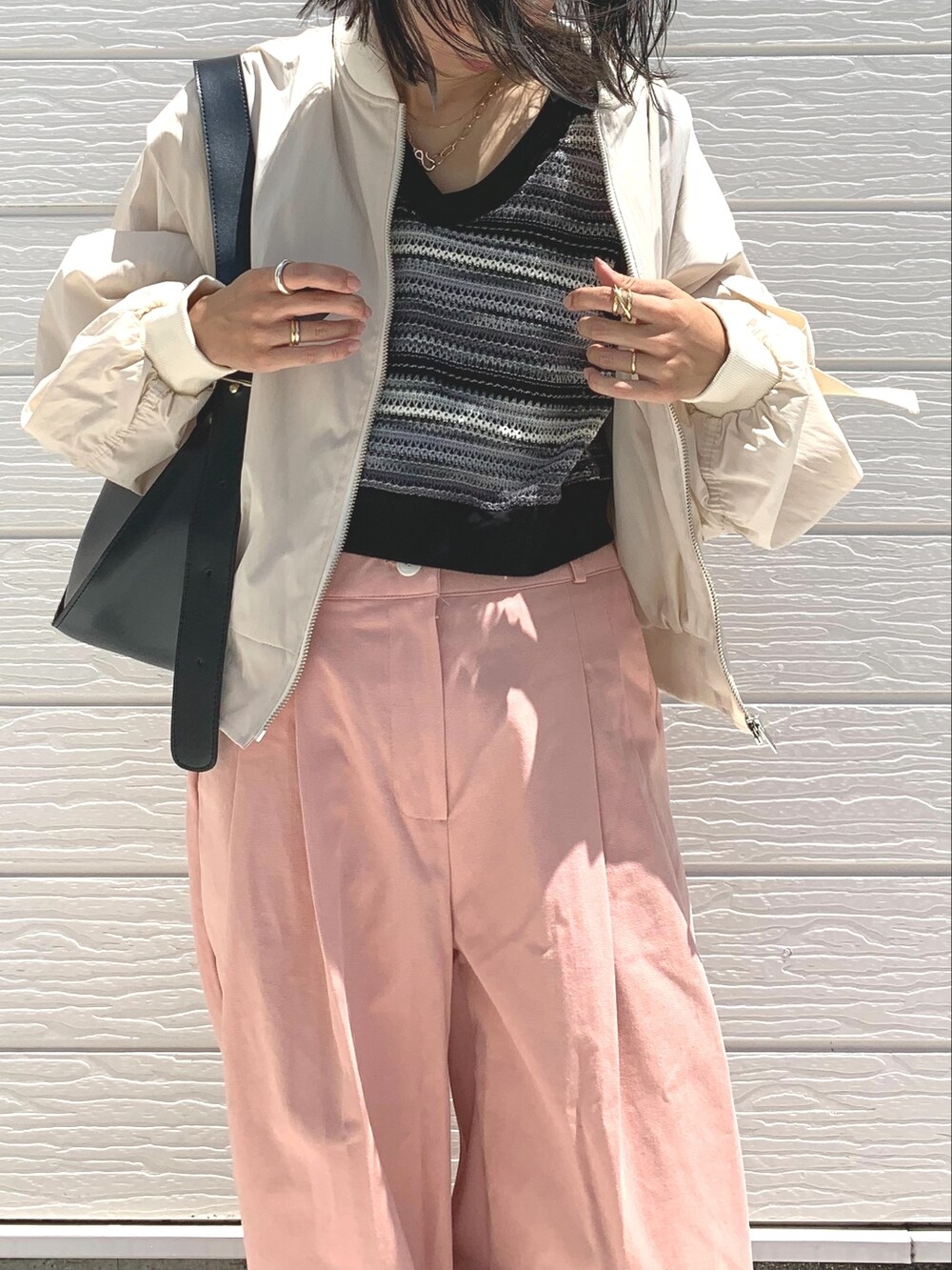 ベージュ系のブルゾン、ブラック系のショルダーバッグ、ブラック系のスニーカーを着用したレディースの夏コーディネートの3枚目の写真