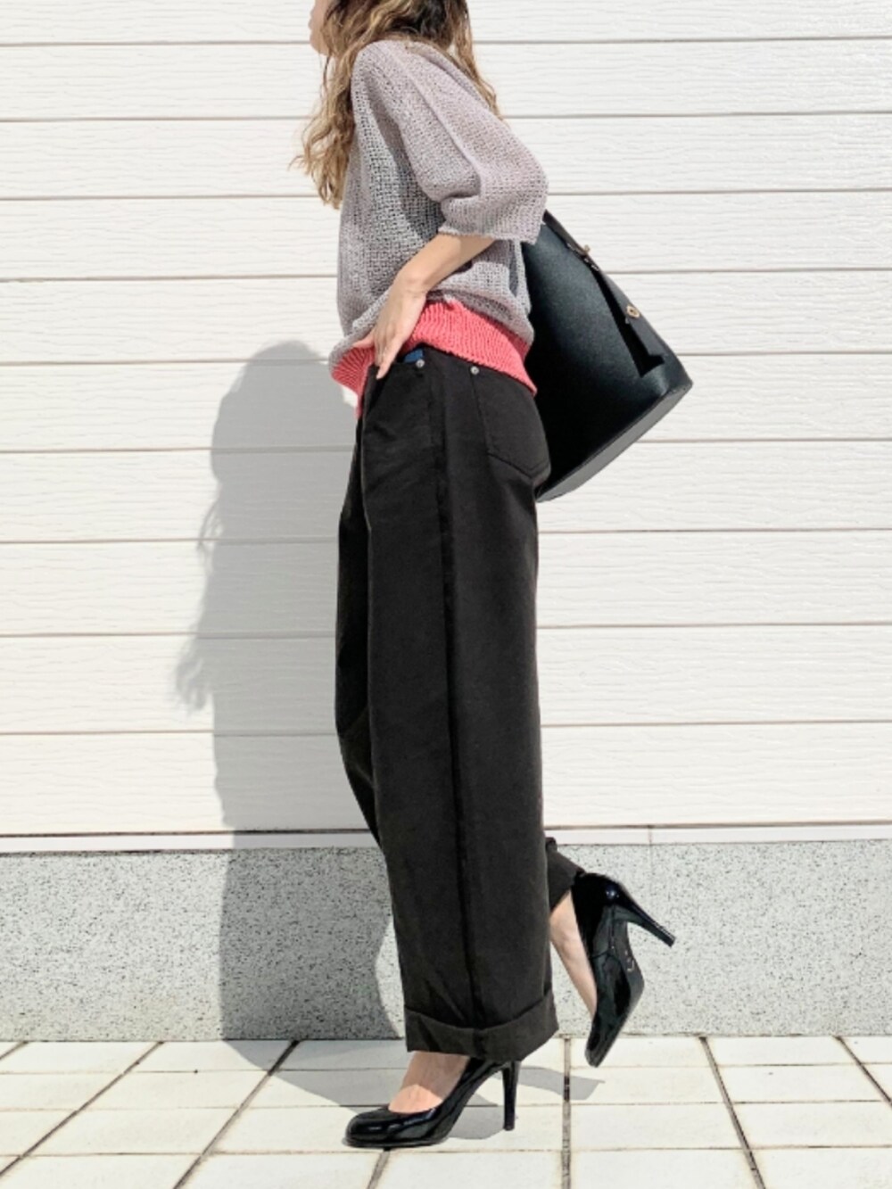 ブラック系のデニムパンツ、ブラック系のキャミソール、ブラック系のトートバッグを着用したレディースの春コーディネートの3枚目の写真