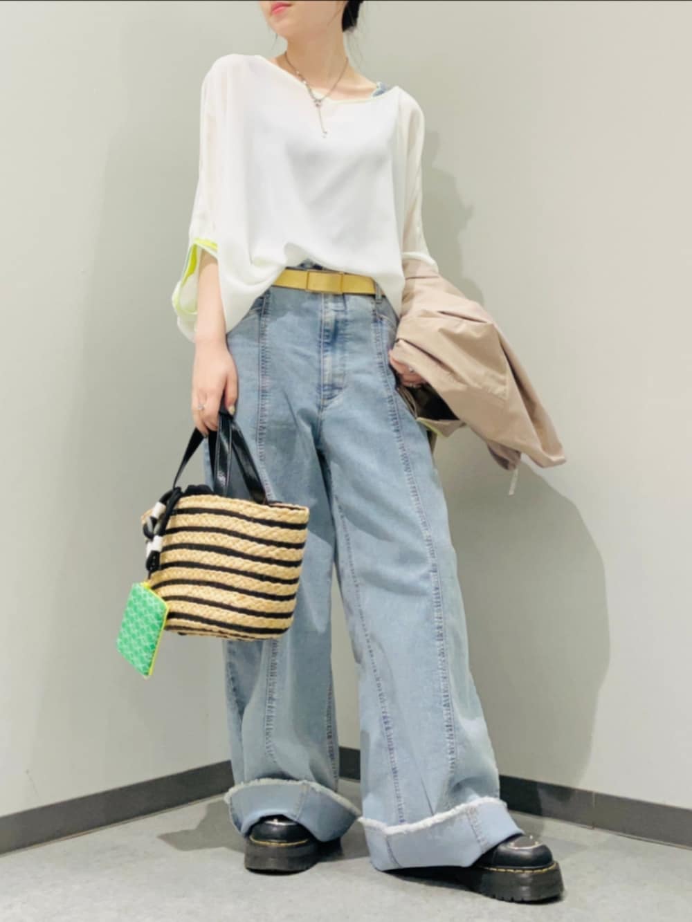 ブラック系のかごバッグ、ブルー系のデニムパンツ、ホワイト系のシャツ/ブラウスを着用したレディースの春コーディネートの3枚目の写真