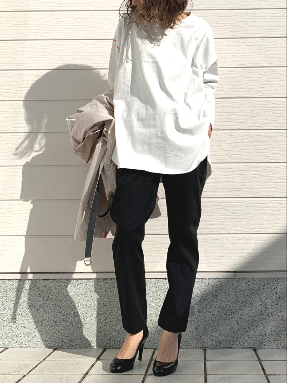 ブラック系のその他パンツ、ホワイト系のTシャツ/カットソー、ベージュ系のその他アウターを着用したレディースの冬コーディネートの2枚目の写真