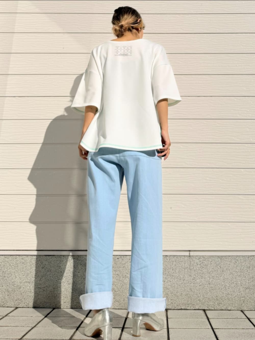 ブルー系のデニムパンツ、ホワイト系のTシャツ/カットソーを着用したレディースの春コーディネートの2枚目の写真